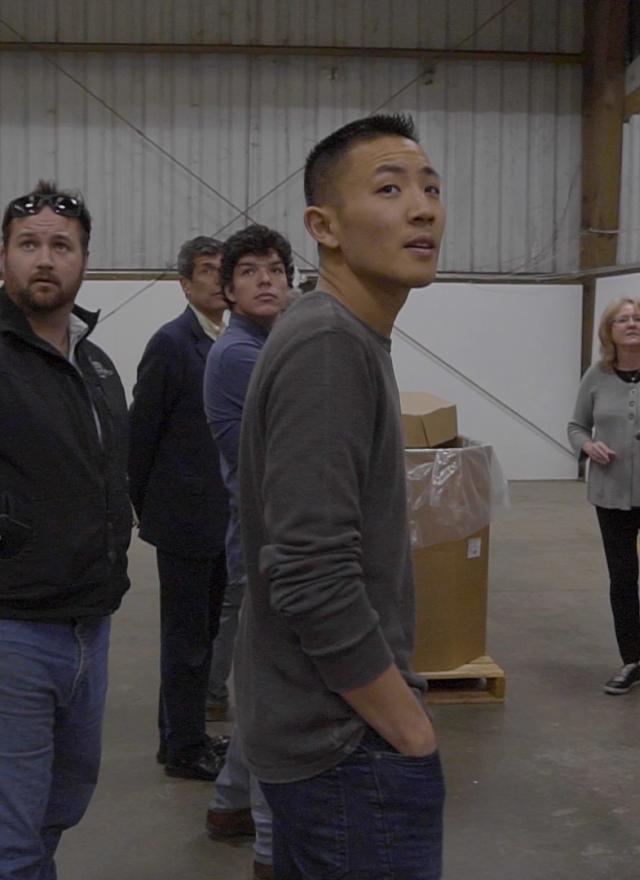 Yuan Cheng and MBA students inside a warehouse