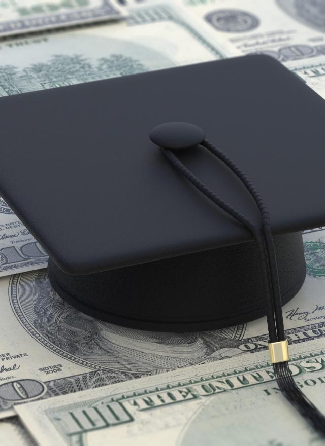 Graduation cap sitting on top of $100 bills