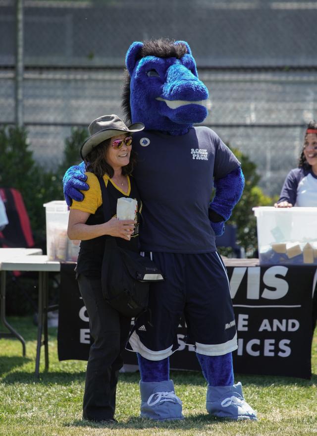 Gunrock the mascot and an UC Davis employee standing on Russell Field 