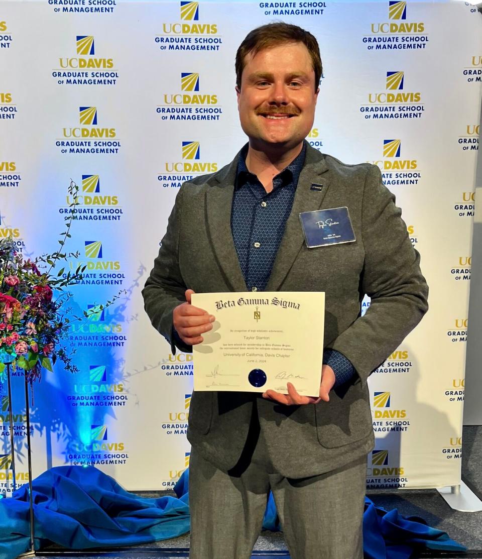 Taylor Stanton holding up a certificate