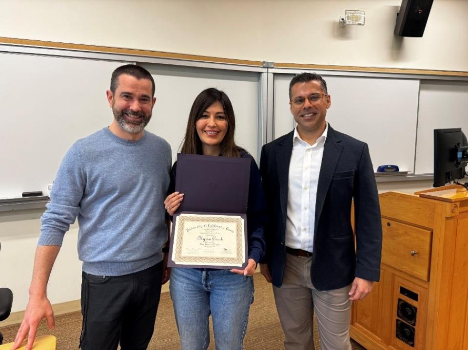 Myrna Robles Couch holding up a certificate with Ben Montpetit and Ashwin Aravindakshan