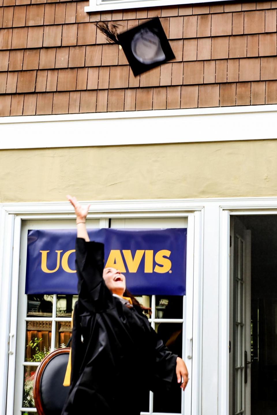 Andrea Ellinghouse tosses graduation cap