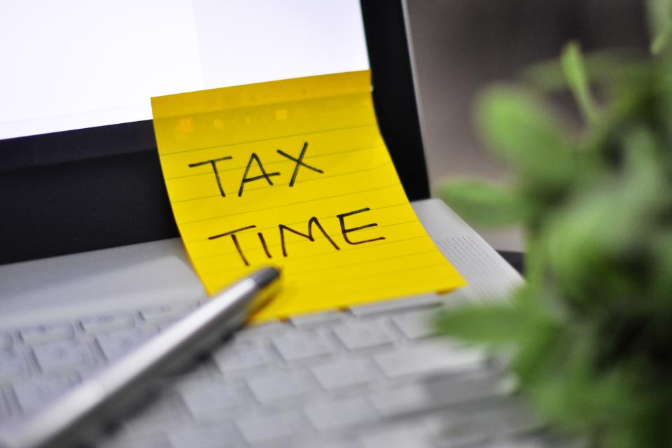 Photo of laptop with sticky note TAX TIME